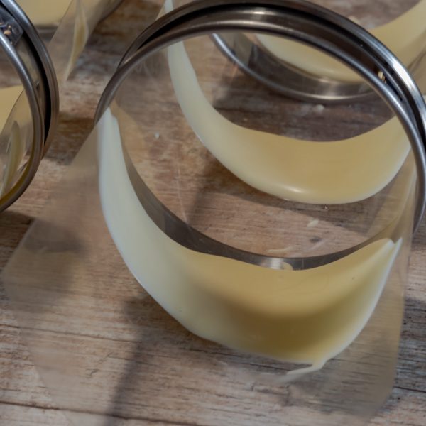 Réalisation de pétales de fleurs en utilisant une feuille de rhodoïd et des cercles à tartelette pour donner la forme.